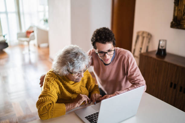 istock Grandson and grandmother using laptop at home 1395406587