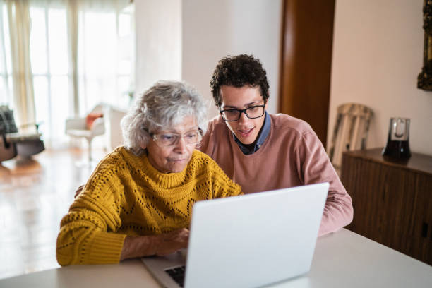 istock Grandson and grandmother using laptop at home 1395406613