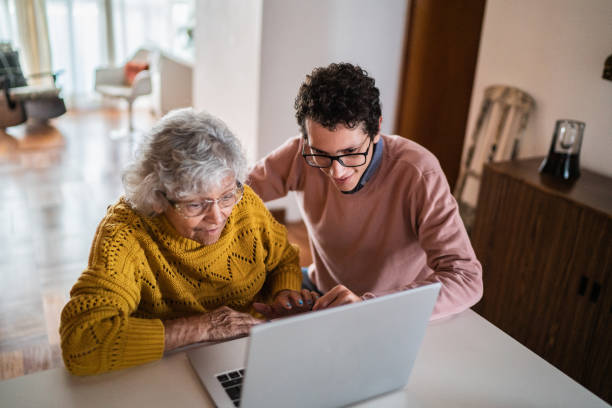 istock Grandson and grandmother using laptop at home 1395406614