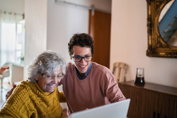 istock Grandson and grandmother using laptop at home 1395406619