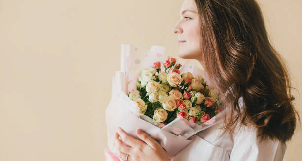 istock Young beautiful woman with roses bouquet. 1395410595