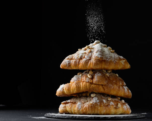istock a stack of baked croissants sprinkled with powdered sugar on a black background 1395414646