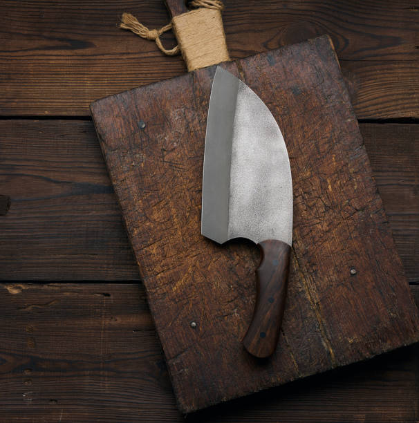 istock Large kitchen knife on an empty wooden cutting board, top view 1395414768