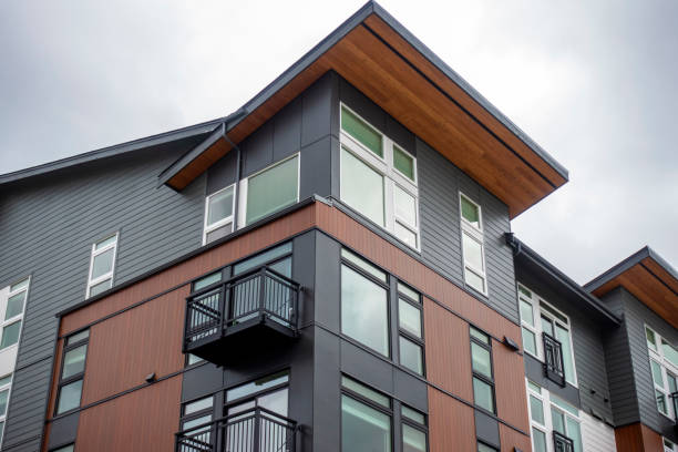 low angle view of a modern style business building, with lots of windows on a sunny, cloudy day - apartment sky housing project building exterior imagens e fotografias de stock