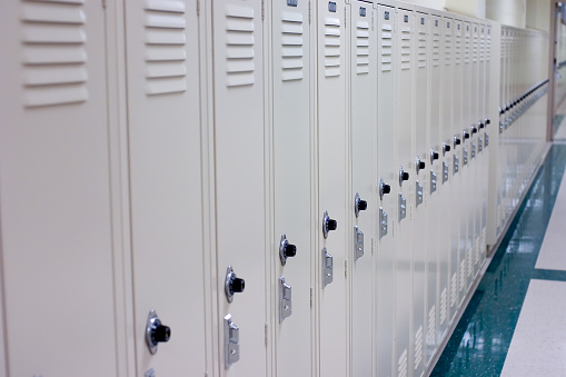 A row of school lockers. Locks on third and fourth locker are in sharp focus.