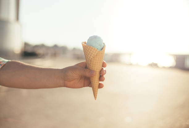 Ice-cream cone in a hand close up.