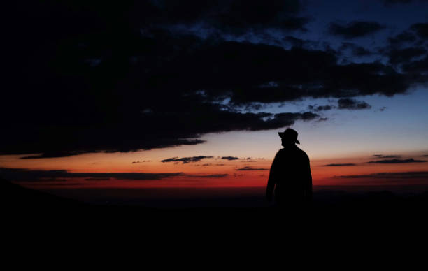 istock silhouette of man in hat at sunset 1395417681