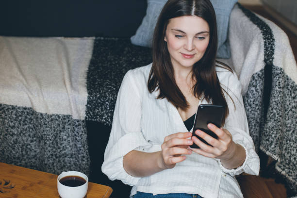 istock Young woman talking on video chat and drinking coffee at home. 1395417856