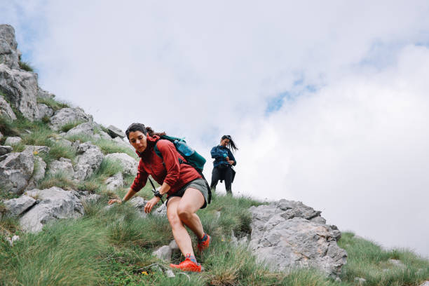grupo de mujeres haciendo senderismo en las montañas - carrera de campo través fotografías e imágenes de stock