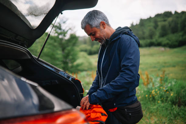 istock mid aged man taking hiking gear from the car 1395419214