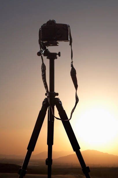 istock Professional camera on tripod overlooking view of nature, taking photograph 1395419220