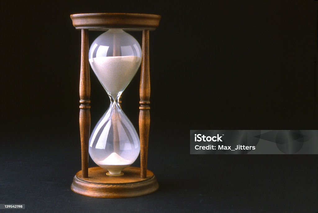 Hourglass antique hourglass isolated against a black backround Black Background Stock Photo