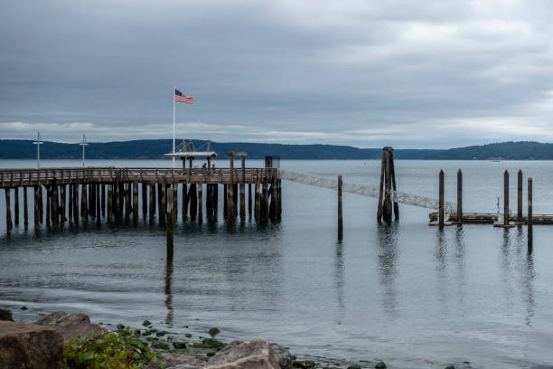 Tacoma, WA USA - circa August 2021: View of a beach by Commencement Bay on an overcast day. Tacoma, WA USA - circa August 2021: View of a beach by Commencement Bay on an overcast day. south puget sound stock pictures, royalty-free photos & images