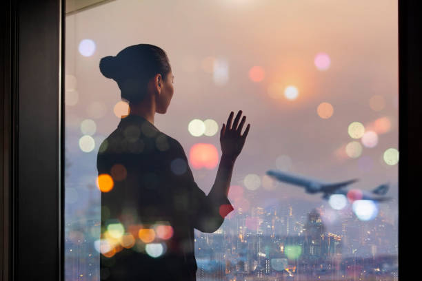 jovem chinesa parada na janela da área de partida do terminal do aeroporto acenando para o avião - urban scene business travel travel asia - fotografias e filmes do acervo