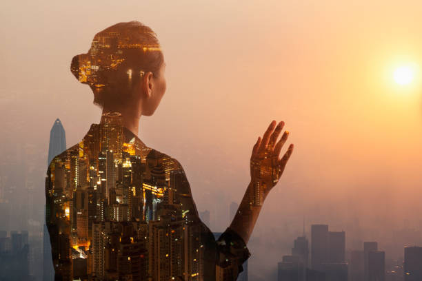 Young woman standing in contemplation in urban city reflection with sunset Young woman standing in contemplation in urban city reflection with sunset, Shenzhen, China sun exposure stock pictures, royalty-free photos & images