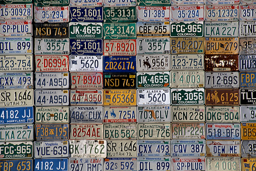 Plain, Montana, USA - June 25, 2009: American license plates of various states on the outside wall of a barn wall.