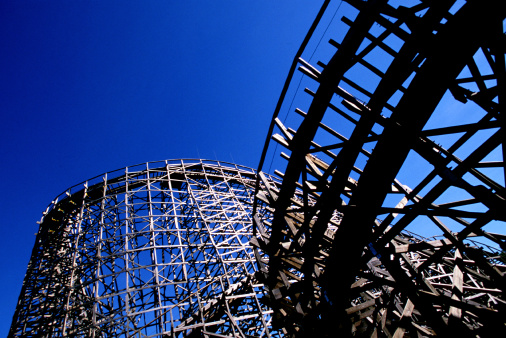 Amusement park wooden roller coaster ride.  Image originally shot on film and a high res scan done, thus it shows the film grain, unlike a digital photograph.