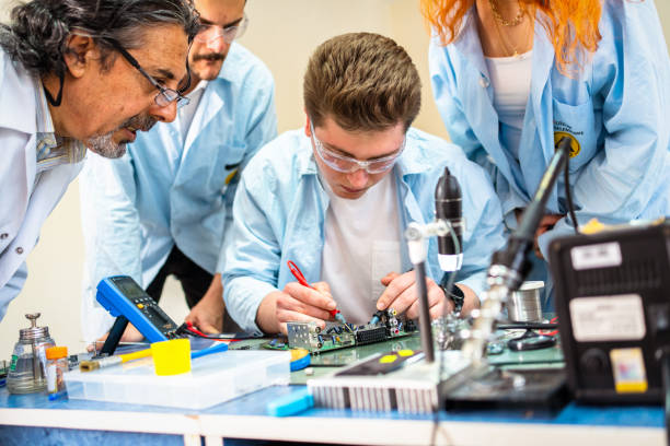 先生の技術的な職業訓練の若者たちのグループ - circuit board electrical equipment engineering technology ストックフォトと画像