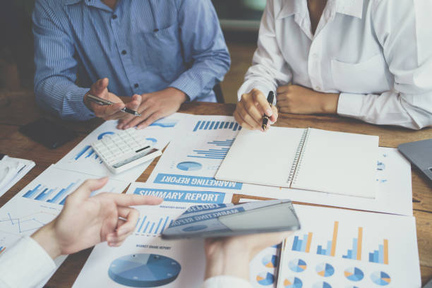 istock Business professionals working together at office desk, Financial adviser working with client, calculating and analyzing data at the table in office. 1395430187