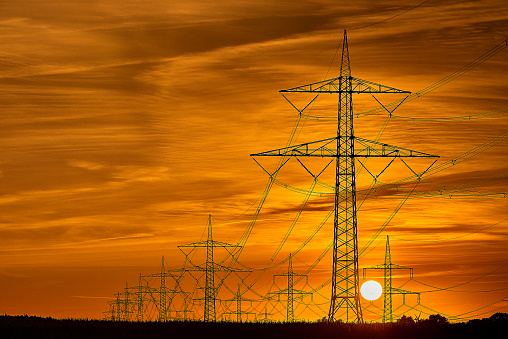 The silhouette of the evening electricity transmission pylon