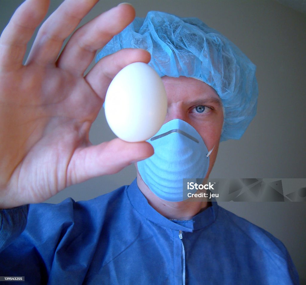 Man holding an egg while practicing food safety Man inspecting egg. Disinfection Stock Photo