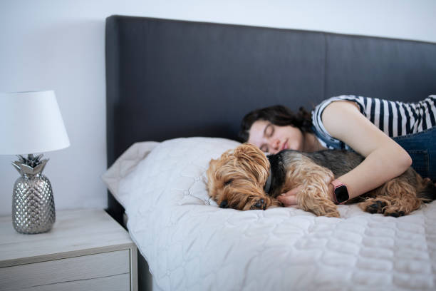 istock Young woman sleeping with her dog. 1395433254