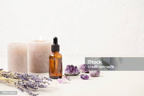 Glass Bottle Of Lavender Essential Oil With Lavender Flowers And Candles And Amethyst Crystals Meditation Zen Aromatherapyspa Massage Concept Stock Photo - Download Image Now