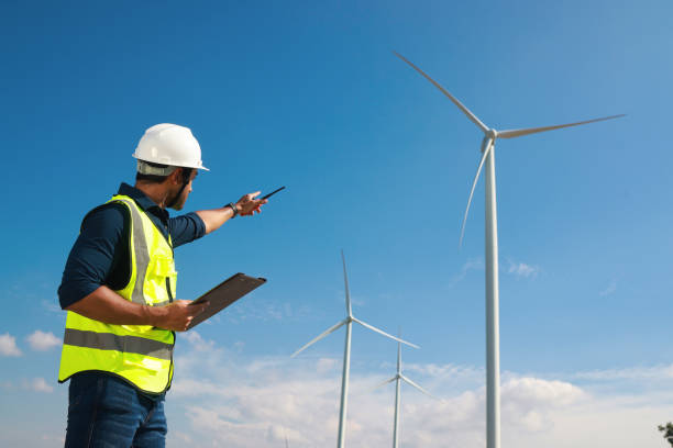 istock Smart engineer wearing safety PPE communicate with team via Walkie Talkie, outdoor working in Wind turbine farm, Engineer working on site at wind turbines farm 1395435581