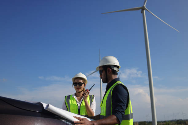 istock Two engineer colleague read drawing working on front vehicle, Wind turbine green energy 1395436107