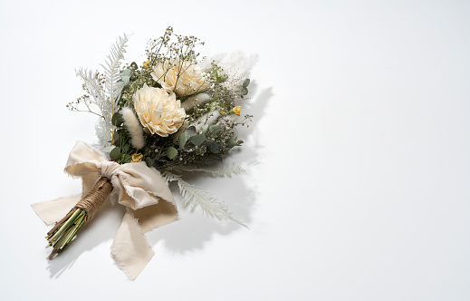 A bouquet of dried flowers placed on a white background. Wedding, festive concept.
