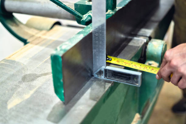 istock Carpenter measuring with a meter and a ruler a machine to be used in the carpentry workshop. 1395444559