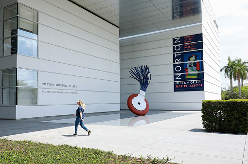 West Palm Beach, Florida, USA -  April 27, 2022:  Young woman walks into the Norton Museum of Art.