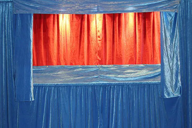 a puppet theater with blue and red velvet curtains - closed