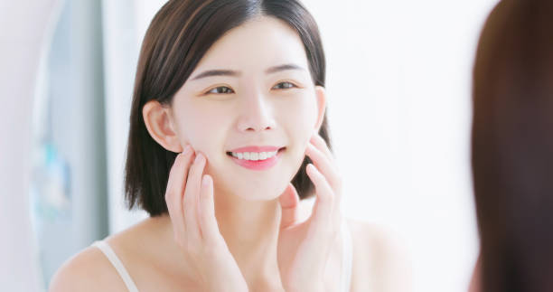 美しさの女性見てミラー - 美容 肌 ストックフォトと画像