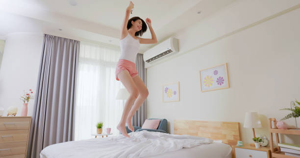 Young woman jump on bed