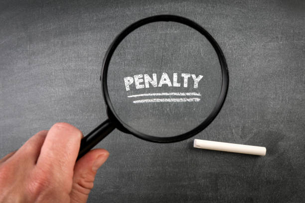 istock PENALTY. Text, magnifying glass and white chalk on a blackboard 1395453136