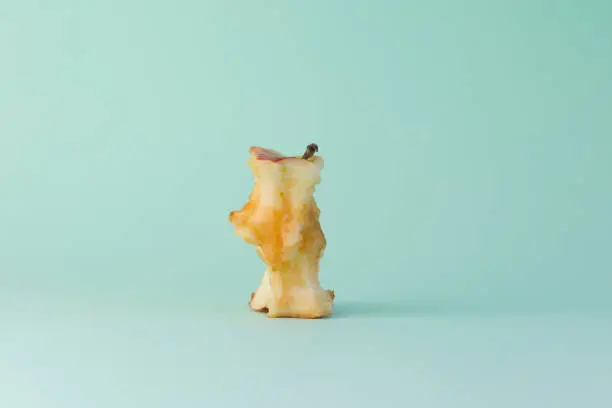 A apple core on a green background
