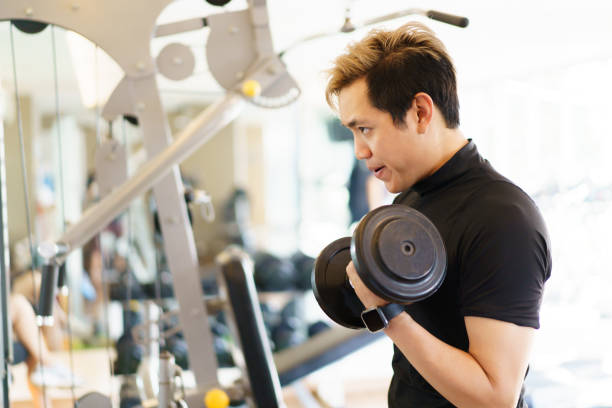 istock Strong sportsman doing a weight training using dumbbell. 1395456165
