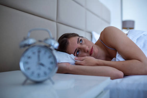 woman with insomnia lying in bed with open eyes. girl in bed suffering insomnia and sleep disorder thinking about his problem at night - insomnia imagens e fotografias de stock