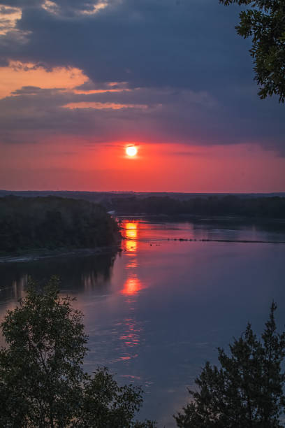 istock Beautiful sunset over Missouri River; setting sun reflect in water 1395467587