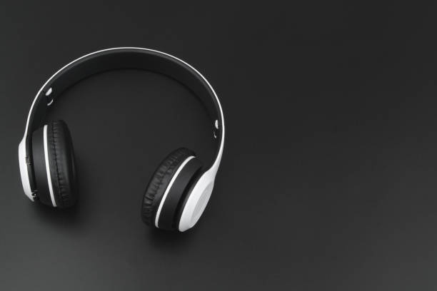 istock Wireless headphones on black background with copy space 1395467755