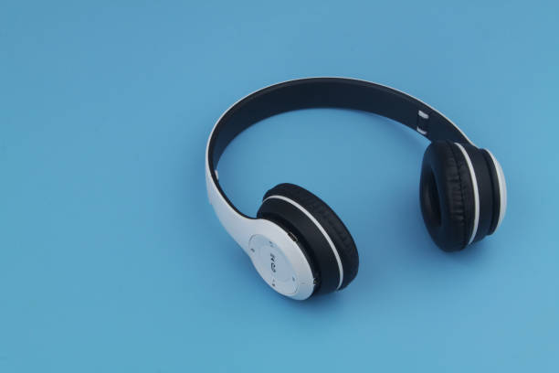 istock Wireless headphones on blue background with copy spac 1395467760