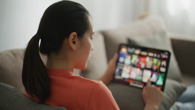 Woman Browsing Internet For TV Movies On Tablet pc