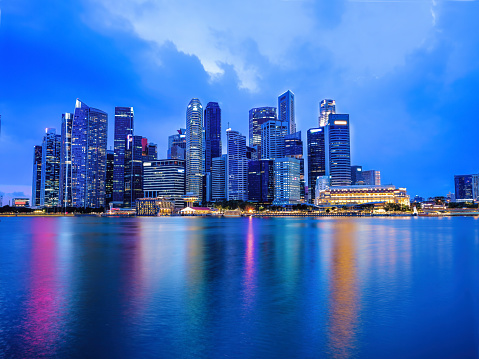 cityscape scenery of group of skyscrapers at central business district of Singapore during twilight sky in evening with reflection on Marina bay water