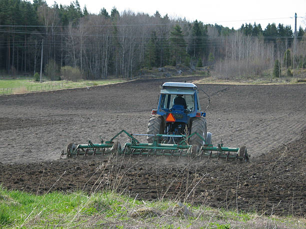 One farmer is harrowing his field. stock photo