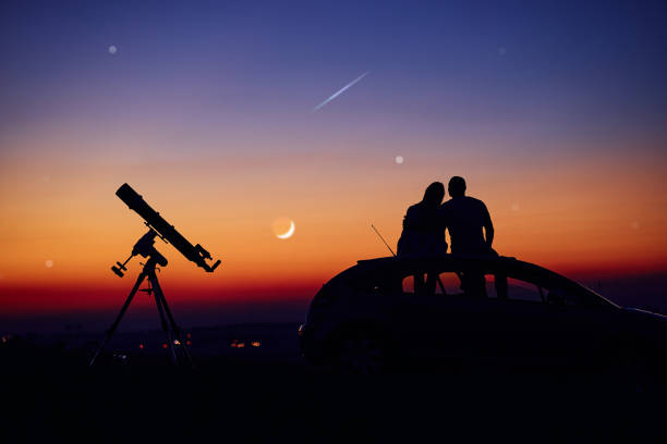 Couple stargazing together with a astronomical telescope. Couple stargazing together with a astronomical telescope. eclipse photos stock pictures, royalty-free photos & images