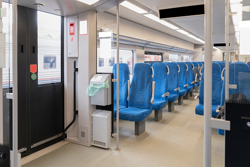 Inside The Wagon Train. Interior of the passenger train with empty blue fabric seats.