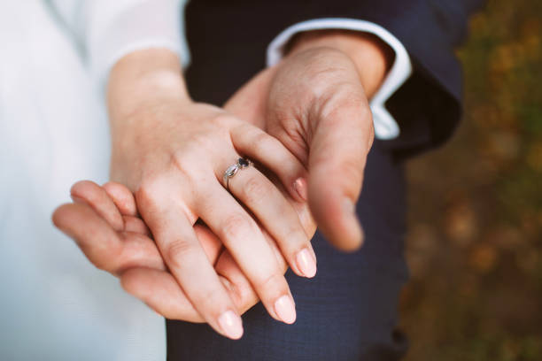 istock Married couple. Bride and groom holding each other hands. 1395472575