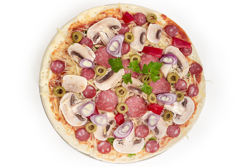 Raw round pizza with different sausages, button mushrooms and green olives prepared for baking, top view on a white background