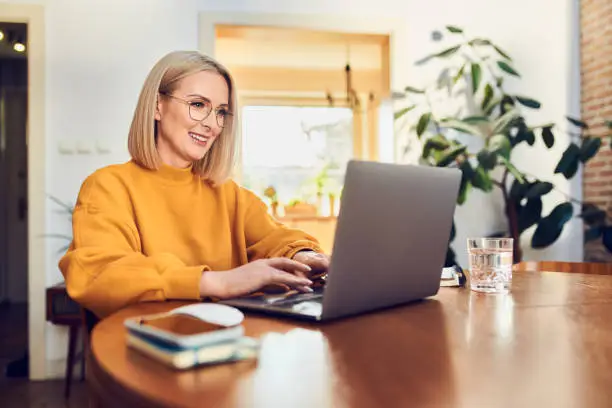 wanita bekerja dengan laptop di rumah